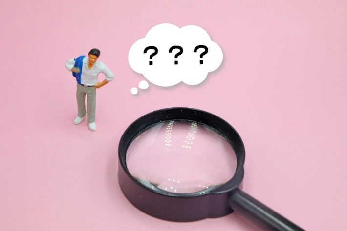 虫めがねと「？」の吹き出しの人