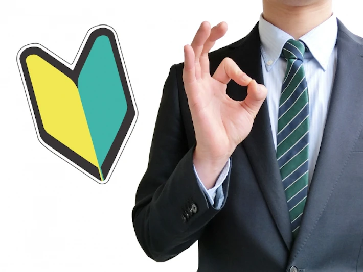 初心者マークとOKサインをしている会社員