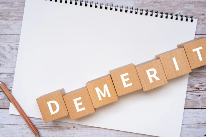 「DEMERIT」の文字ブロックと画用紙