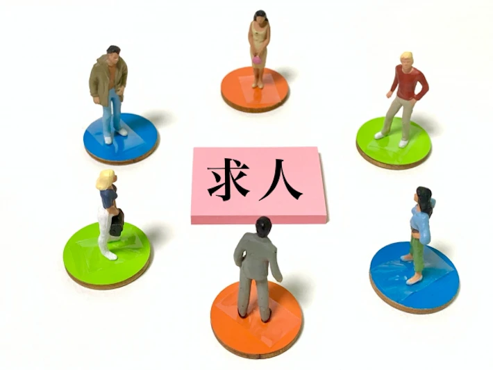 「求人」と書かれたメモを見る複数の会社員