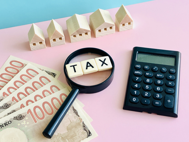 電卓とお札と「TAX」の文字ブロック