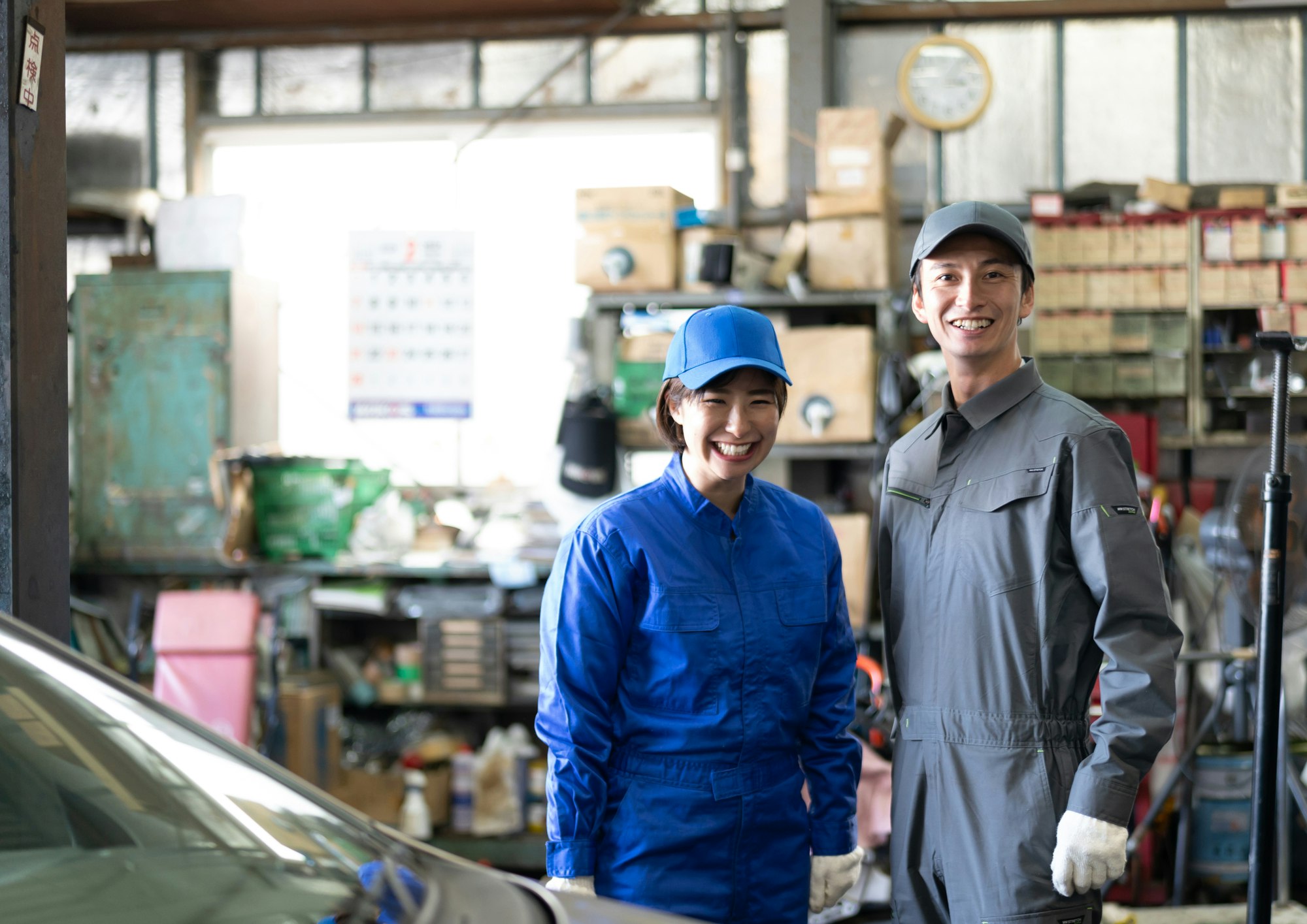自動車整備工場で働く男性と女性の自動車整備士