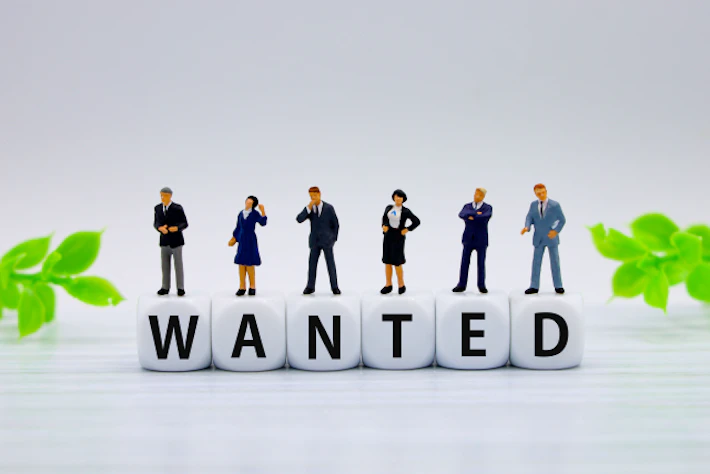 「WANTED」の文字ブロックと会社員