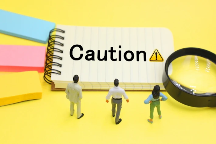 「CAUTION」と書かれたメモと会社員