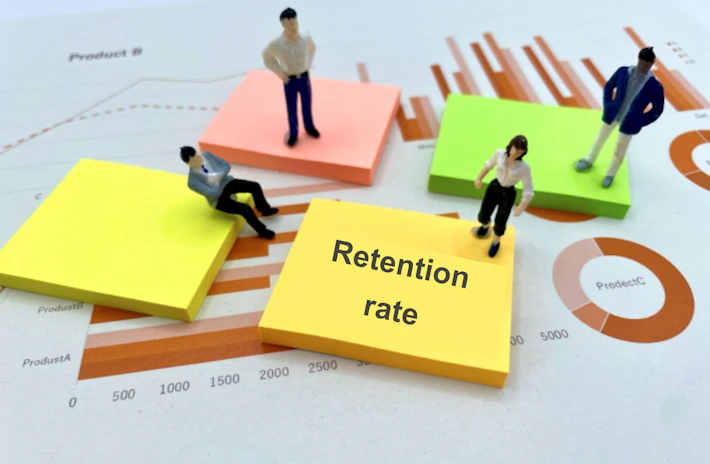 「Retention rate」と書かれたメモとグラフと会社員