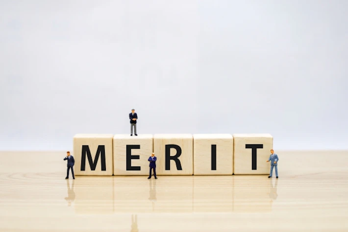 「MERIT」と書かれたブロックと会社員