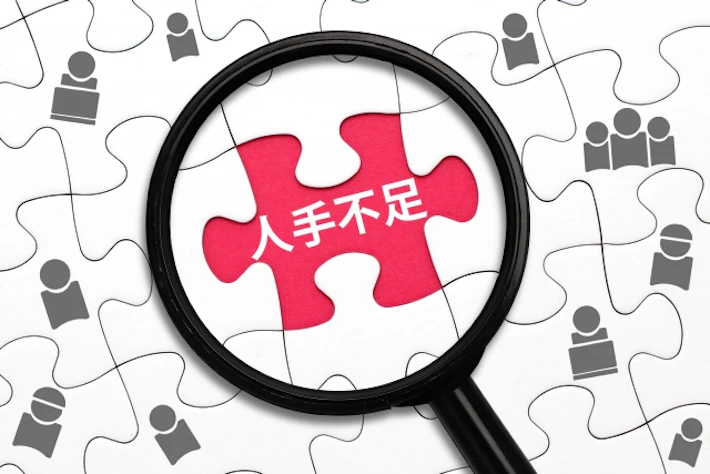 「人手不足」と書かれた虫めがね
