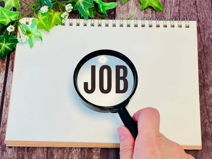 「JOB」と書かれたスケッチブックと虫めがね