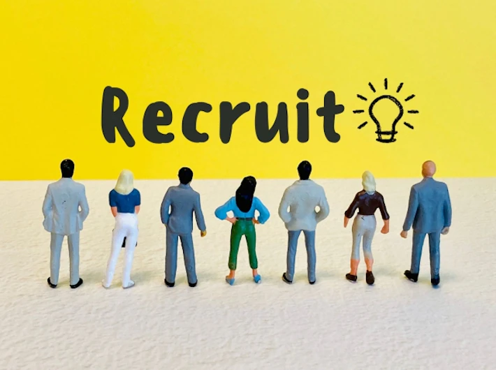 「Recruit」の文字を見る複数の会社員