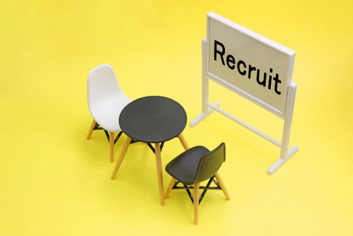 「Recruit」の文字が書かれたホワイトボードと面接セット
