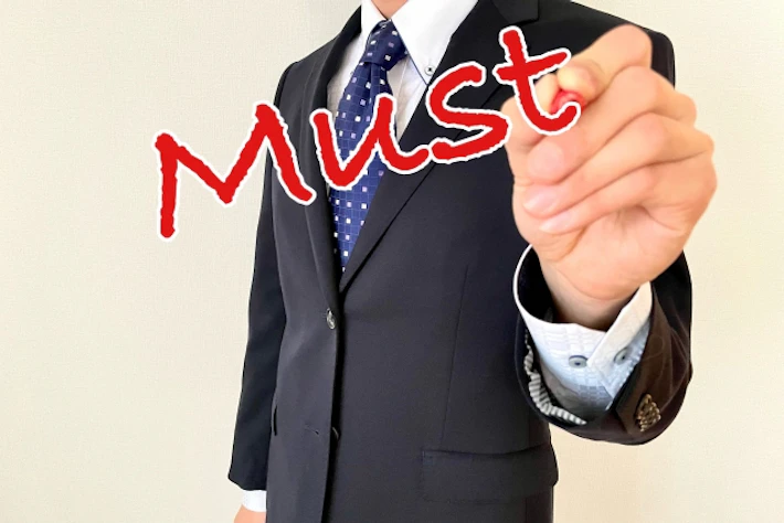 会社員が「MUST」を書く様子