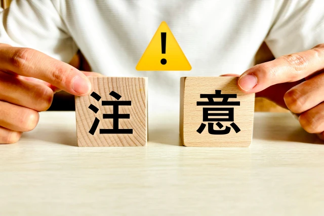 「注意」のプレートを持つ人