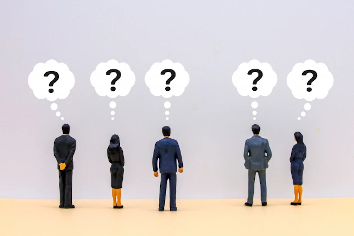 「?」の吹き出しと会社員の後ろ姿