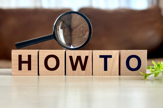 「HOWTO」の文字ブロックと虫めがね