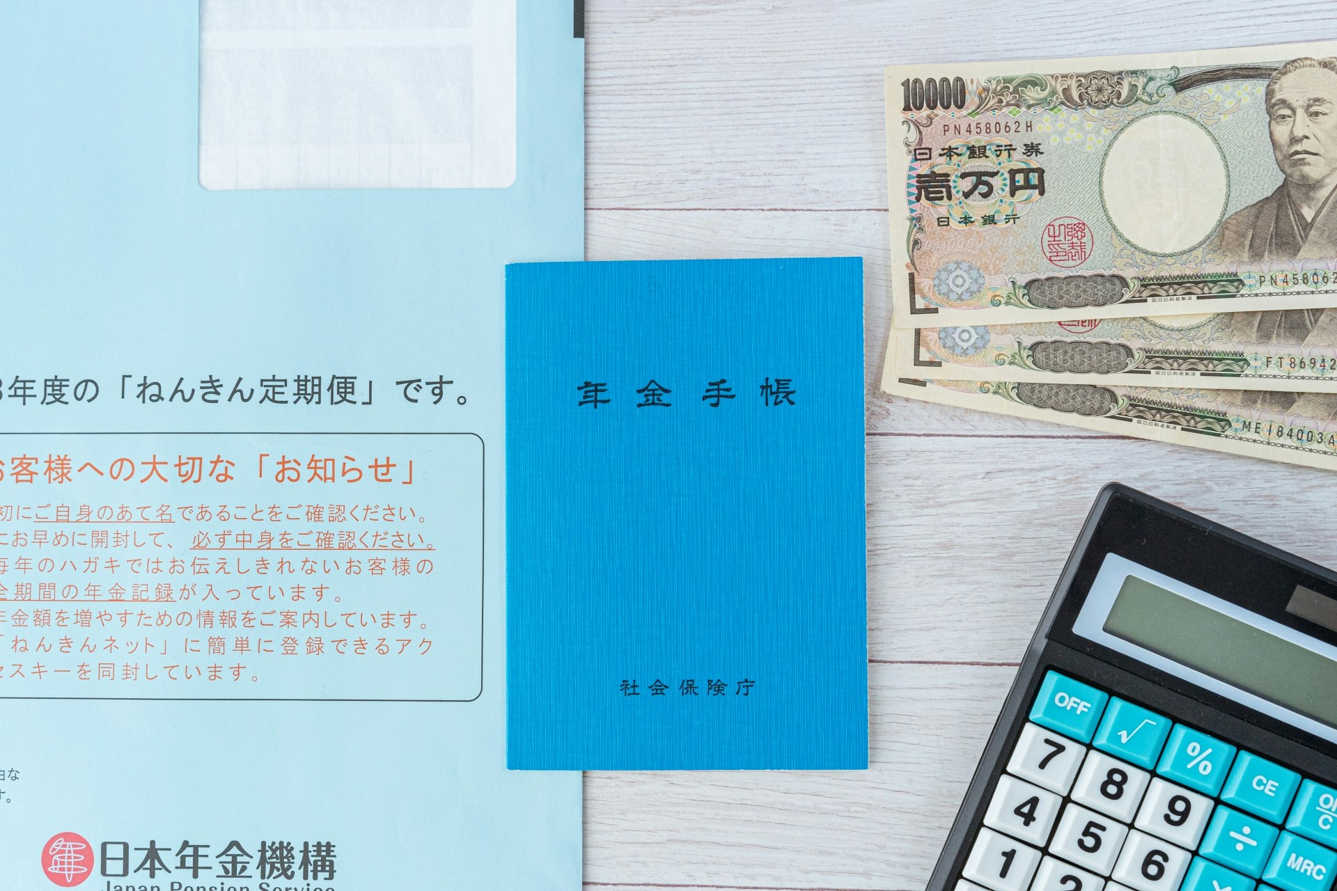 青い表紙の年金手帳と封書で届いた「ねんきん定期便」