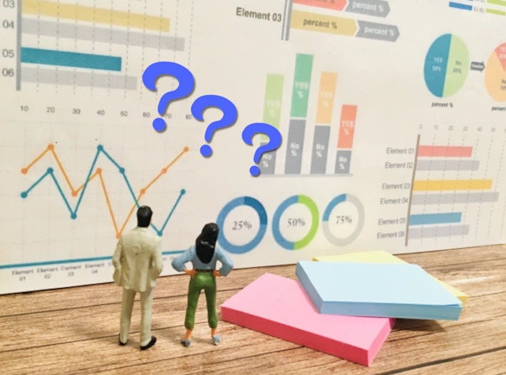 チャート表を見る会社員の後ろ姿と「?」マーク