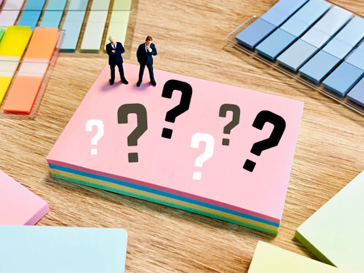「？」が書かれたメモと考える会社員