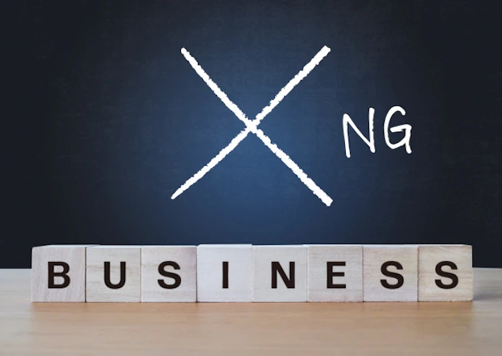 「BUSINESS]のブロック文字と「NG」と書かれた黒板