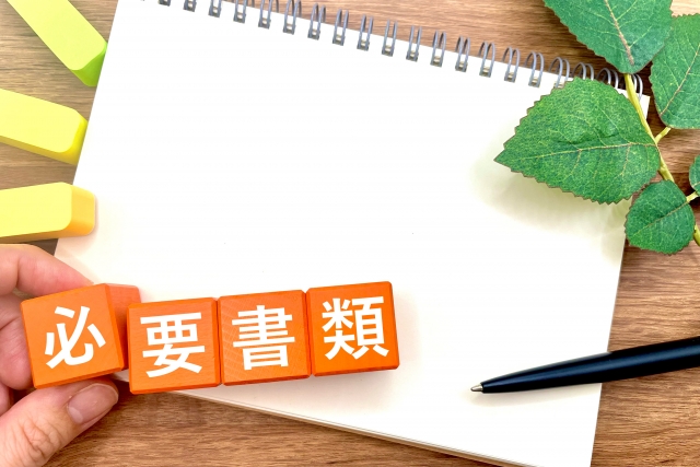 「必要書類」と書かれた文字ブロックとスケッチブック