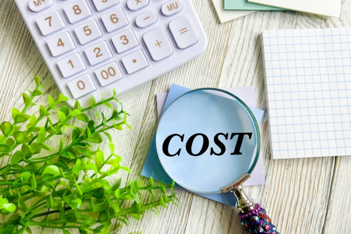 電卓と「COST」と書かれた虫めがね