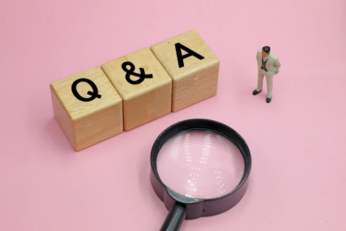 「Q&A」の文字ブロックと会社員と虫めがね