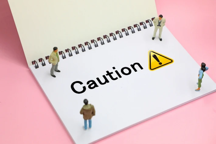 「Caution」が書かれたスケッチブックと会社員