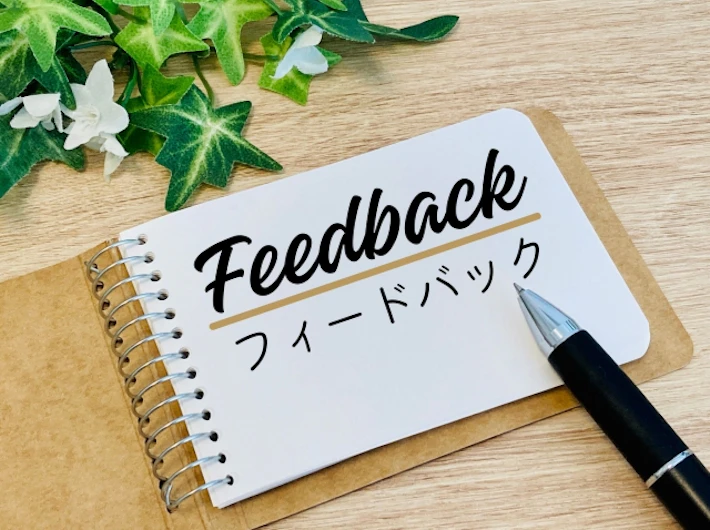 「フィードバック」と書かれたノートとペン