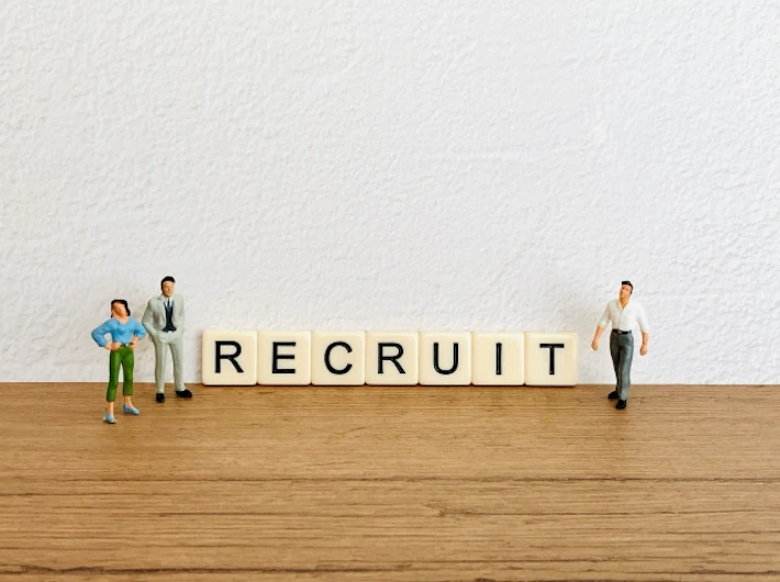 「RECRUIT」の文字ブロックと会社員