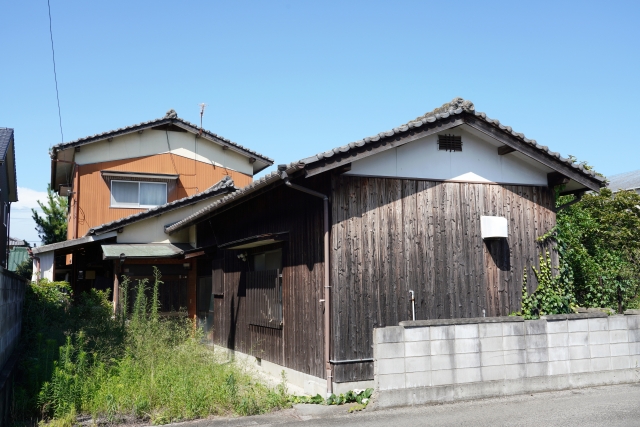 草刈りが放置され荒れた空き家の庭の画像