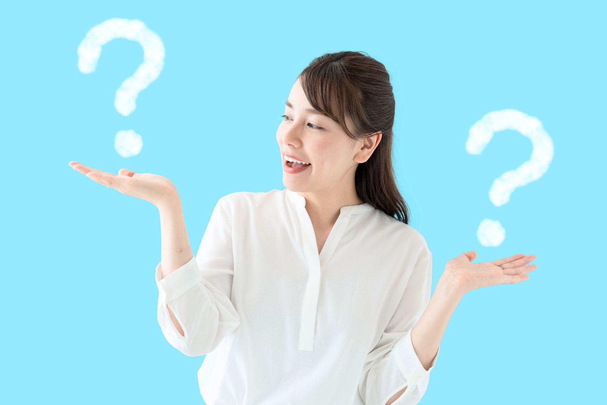 青い背景の前で両手を広げ、比較検討する様子の女性。