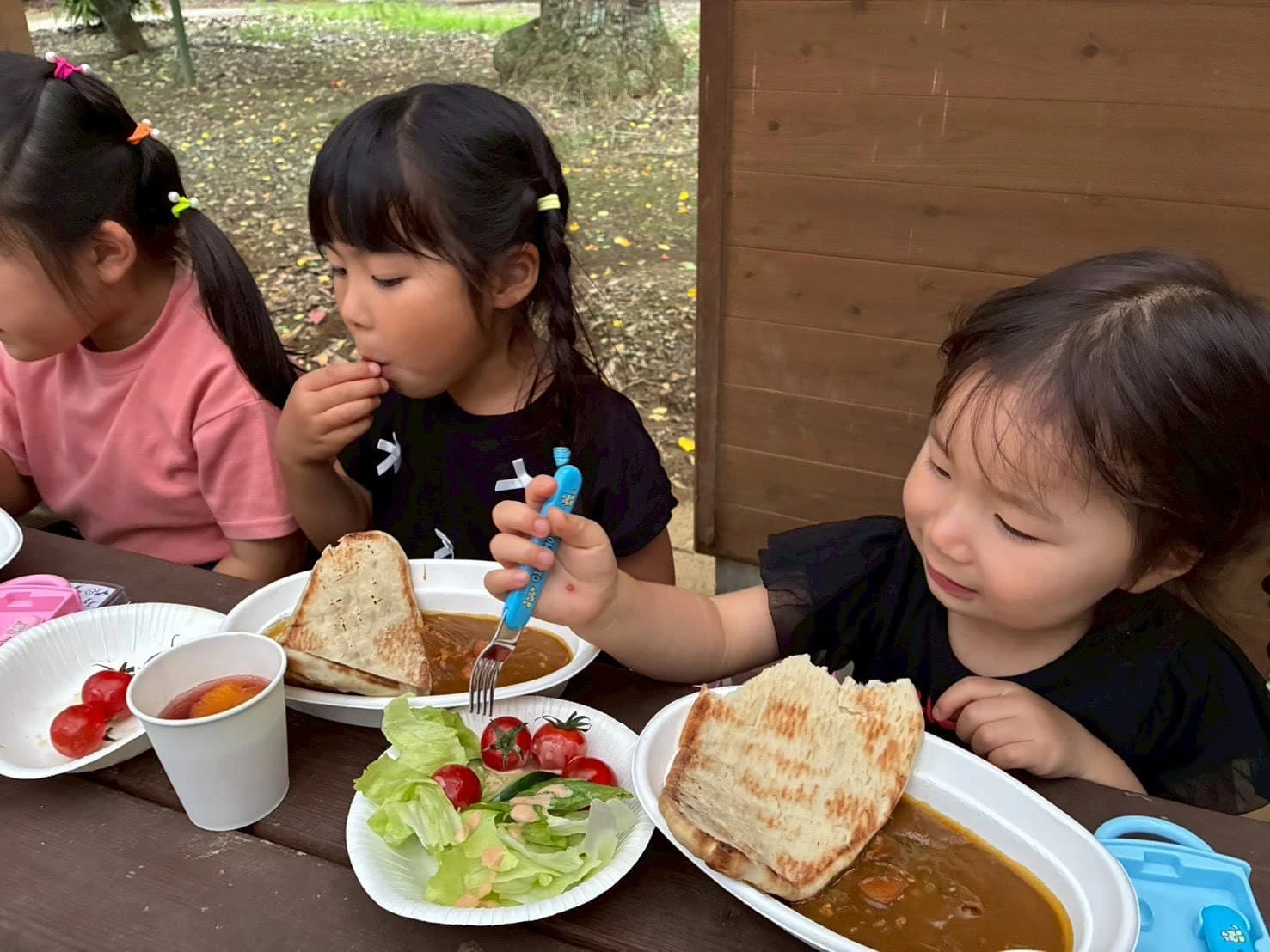 みもみ幼稚園の体操教室の一環でキャンプへ行きカレーを食べる女の子
