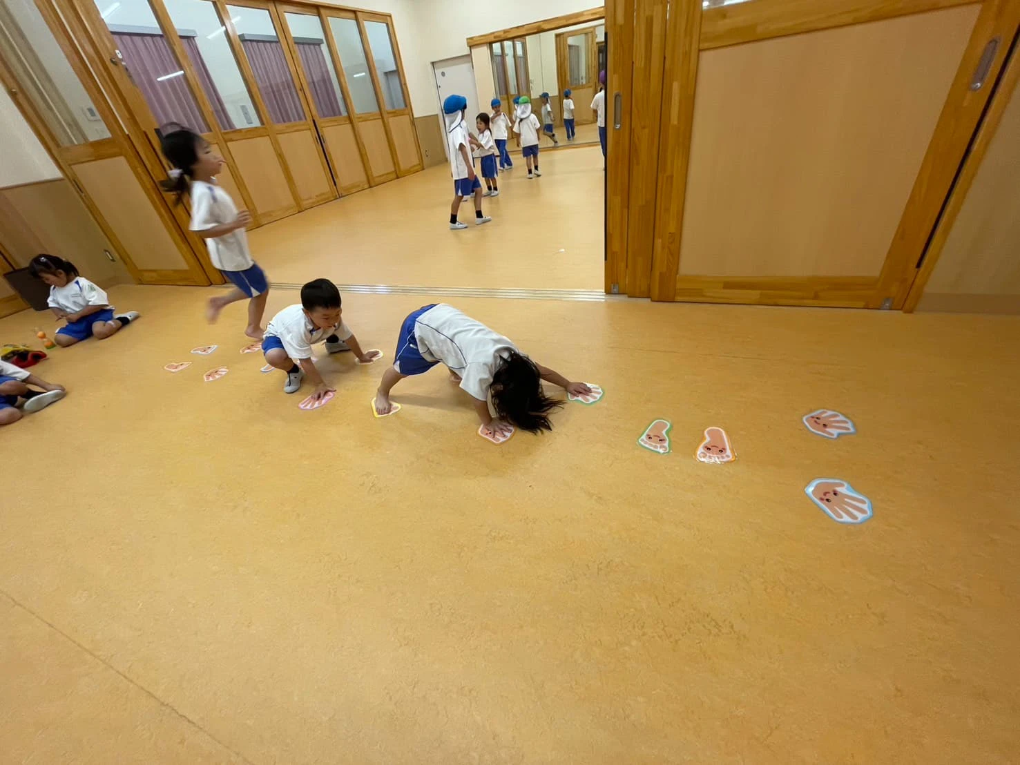 みもみ幼稚園の広い部屋で体を動かして遊ぶ子供たち