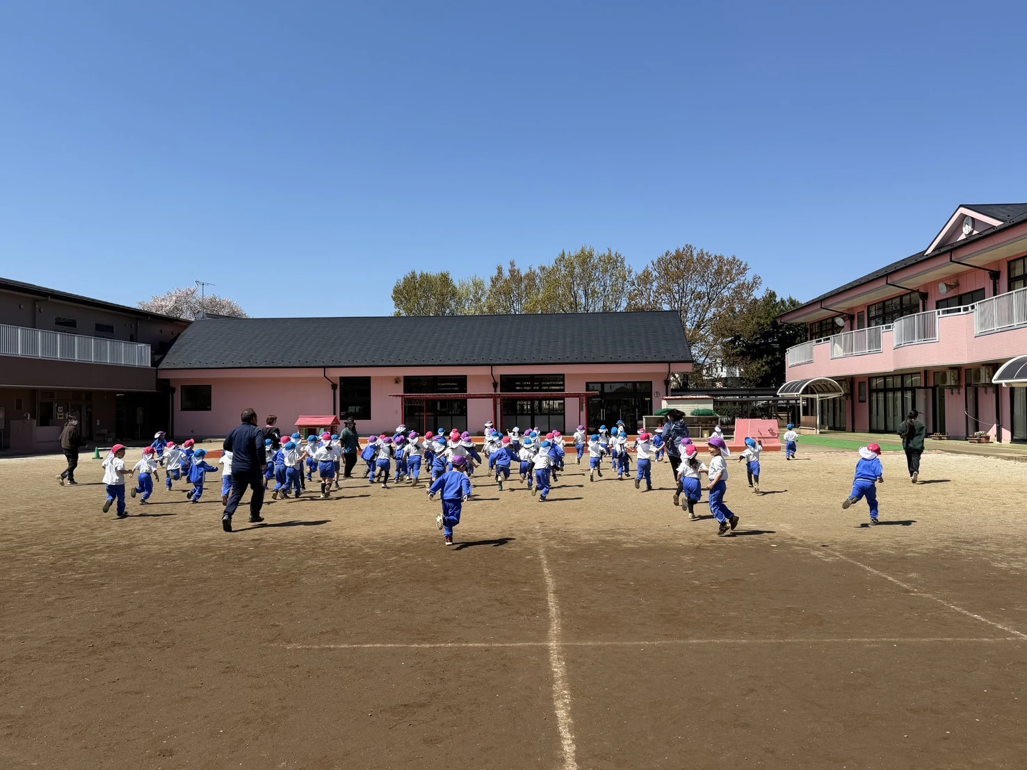 園庭で集団ゲームをする年長組