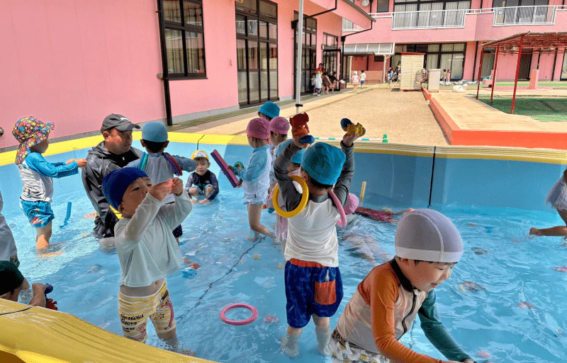 幼稚園のプールでおもちゃを使って遊ぶ年少さん