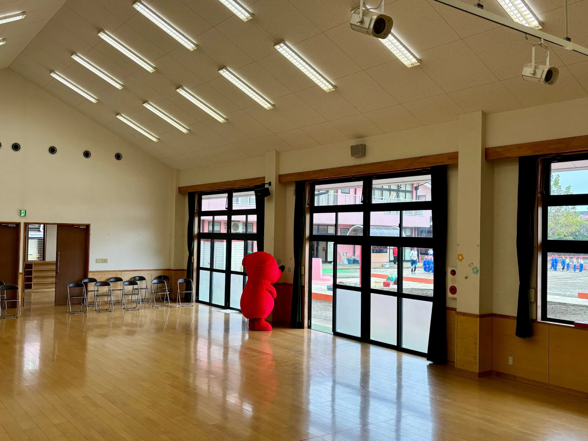 幼稚園のホールでチーバくんが壁を向いて隠れているところ