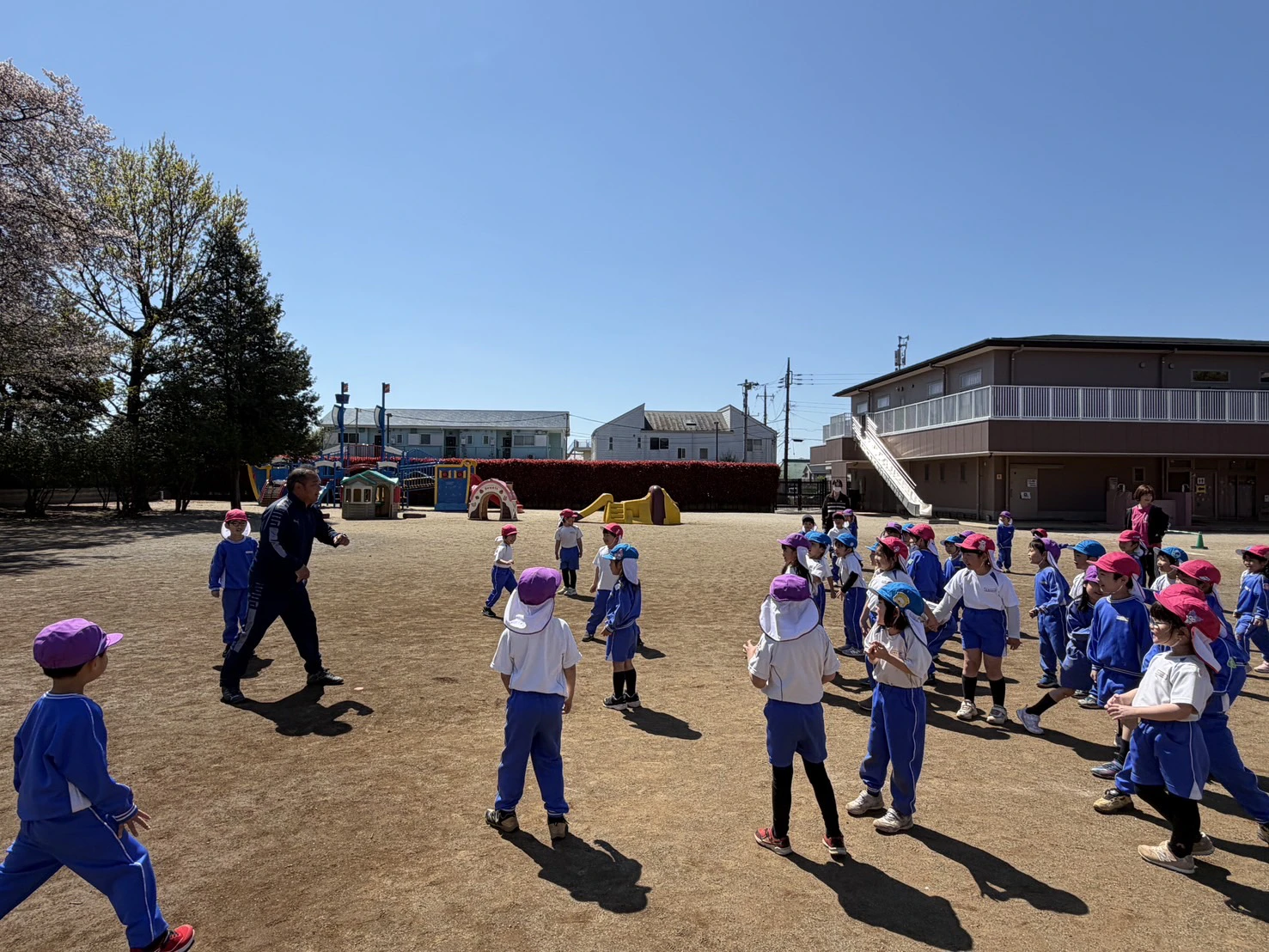 園庭で集団ゲームをする年長組