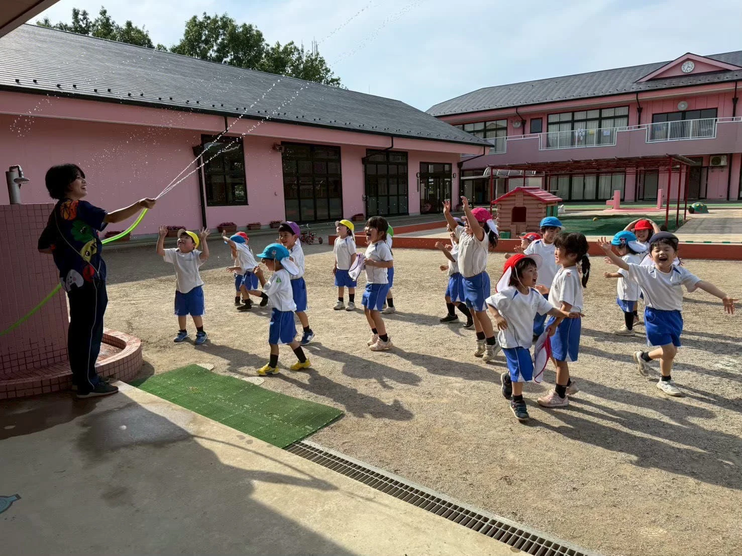 みもみ幼稚園の園庭で水遊びをする子ども達