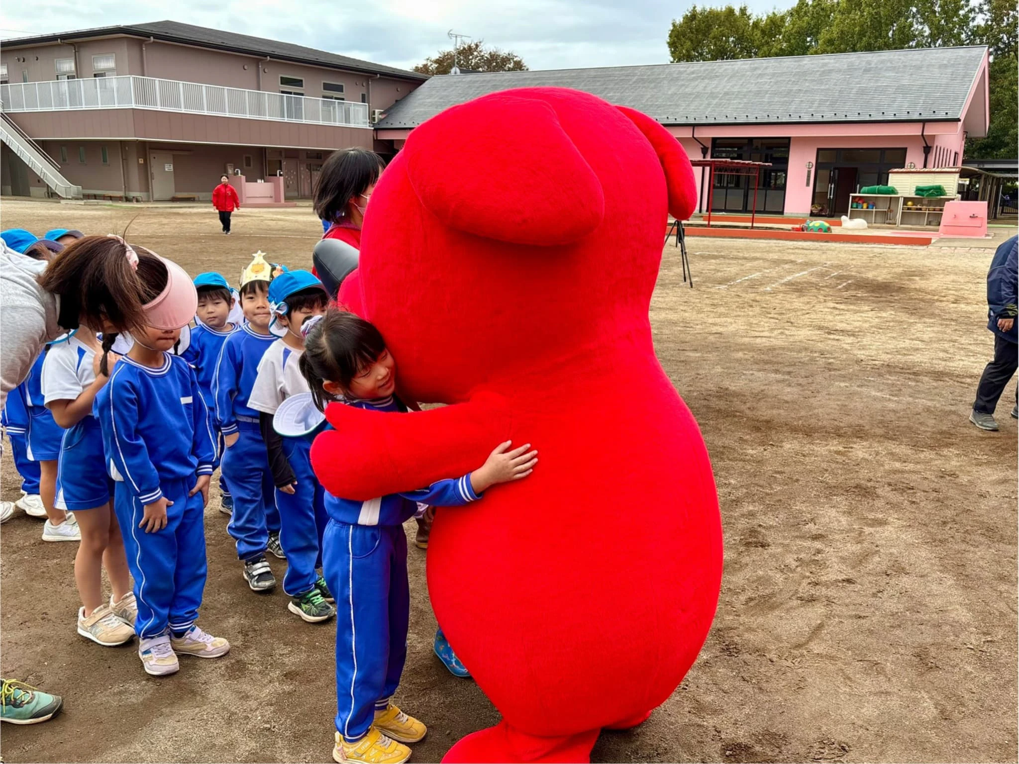 年長の女の子とチーバくんがハグをしているところ