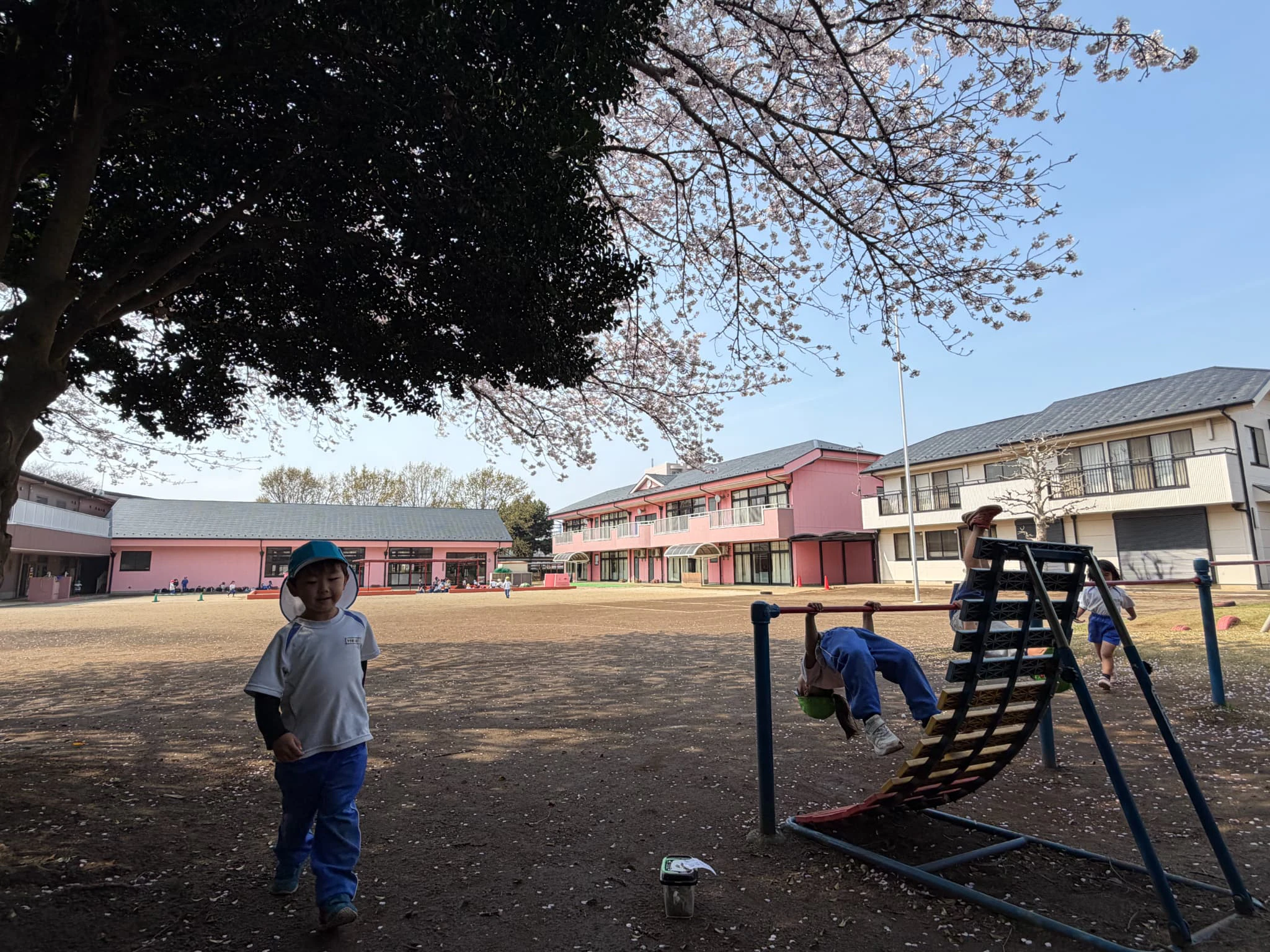 園庭の鉄棒で遊ぶ子どもたち