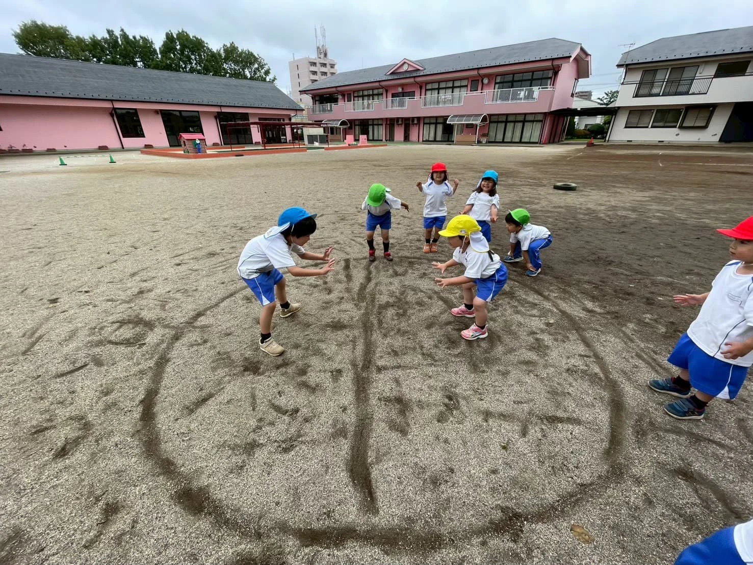 みもみ幼稚園の園庭で土俵を描き相撲をする子どもたち