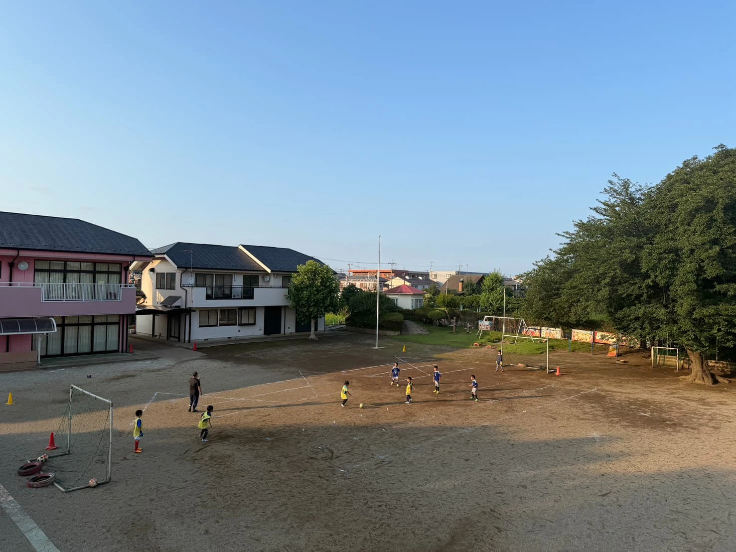 みもみ幼稚園の園庭でサッカーをする小学生