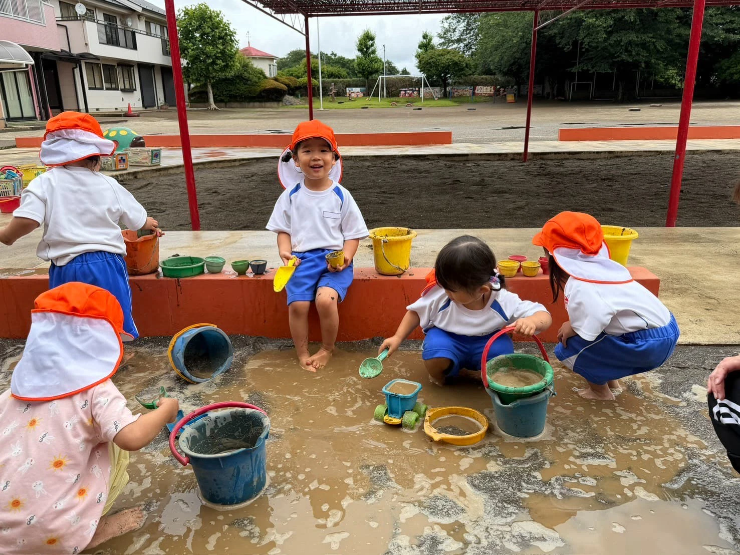 みもみ幼稚園の水たまりで泥遊びをする子どもたち