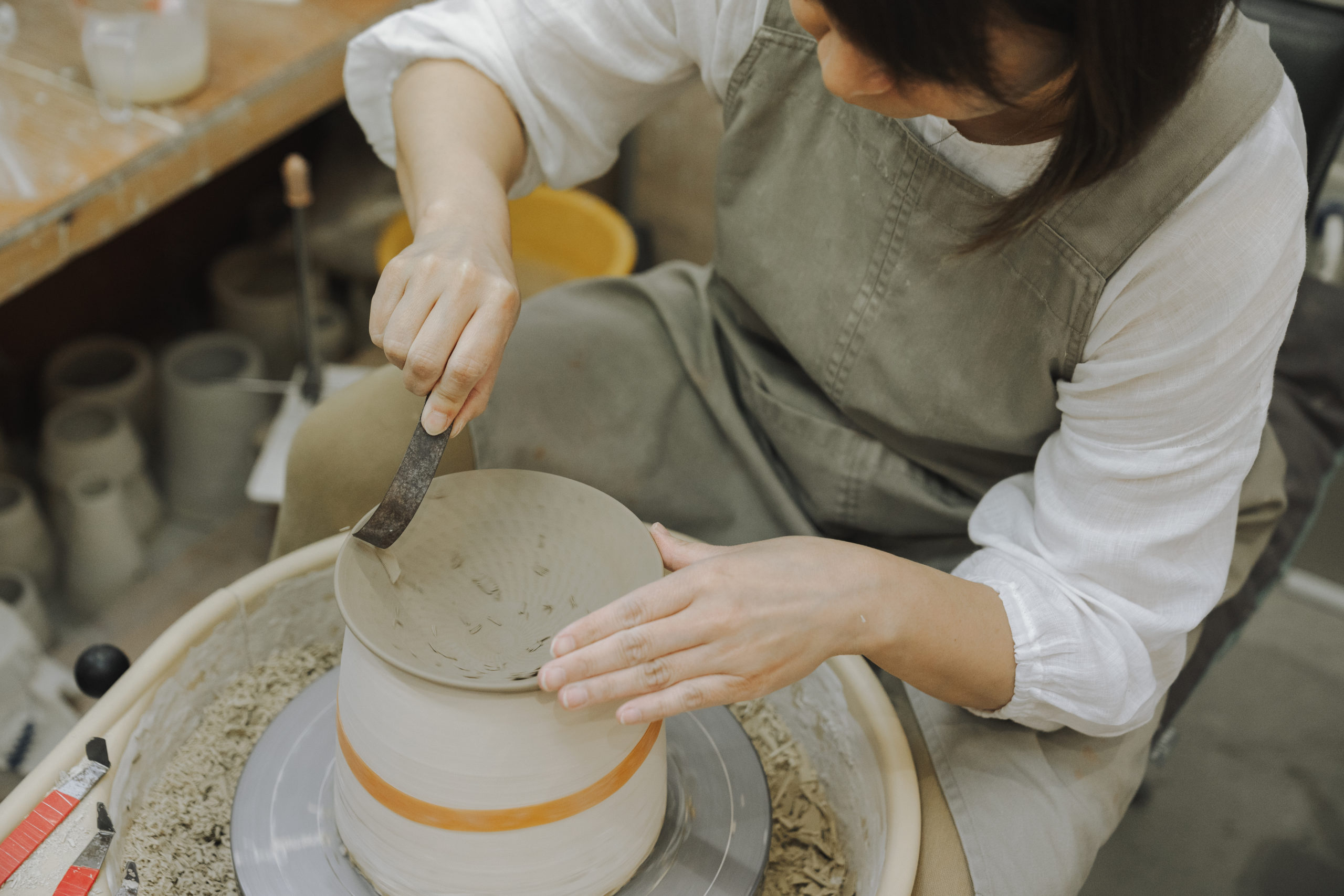 小石原焼の技法である飛鉋を入れるまどかさん