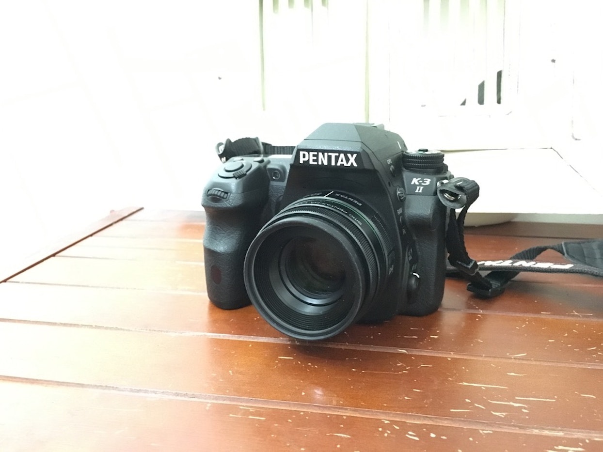 Pentaxのデジタル一眼レフカメラK-3 IIが木製の表面に置かれている