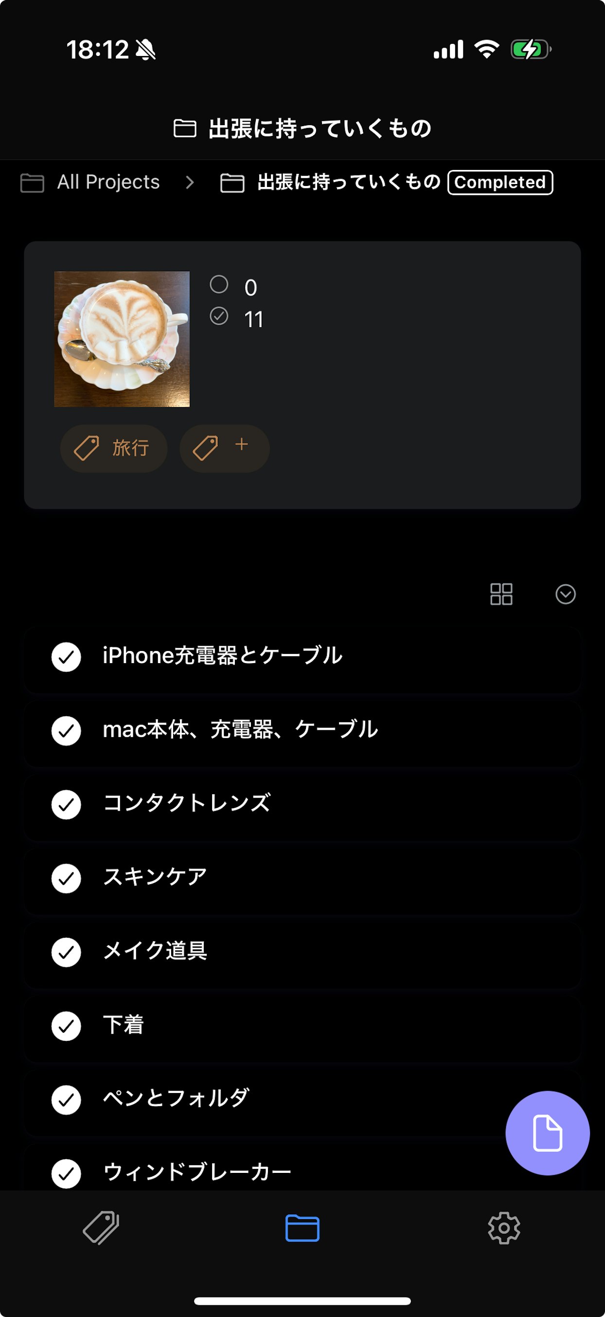 スマートフォンの画面に表示されたタスク管理アプリ。上部に「出張に持っていくもの」というタイトルがあり、その下にコーヒーカップの写真と複数のチェックリスト項目が表示されている。