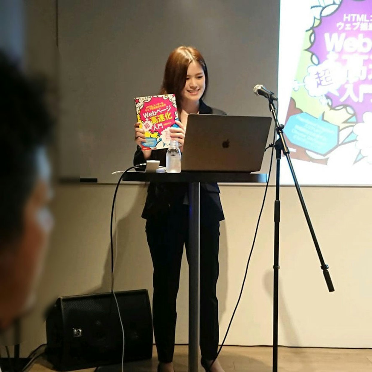 ステージに立って本の説明をする著者