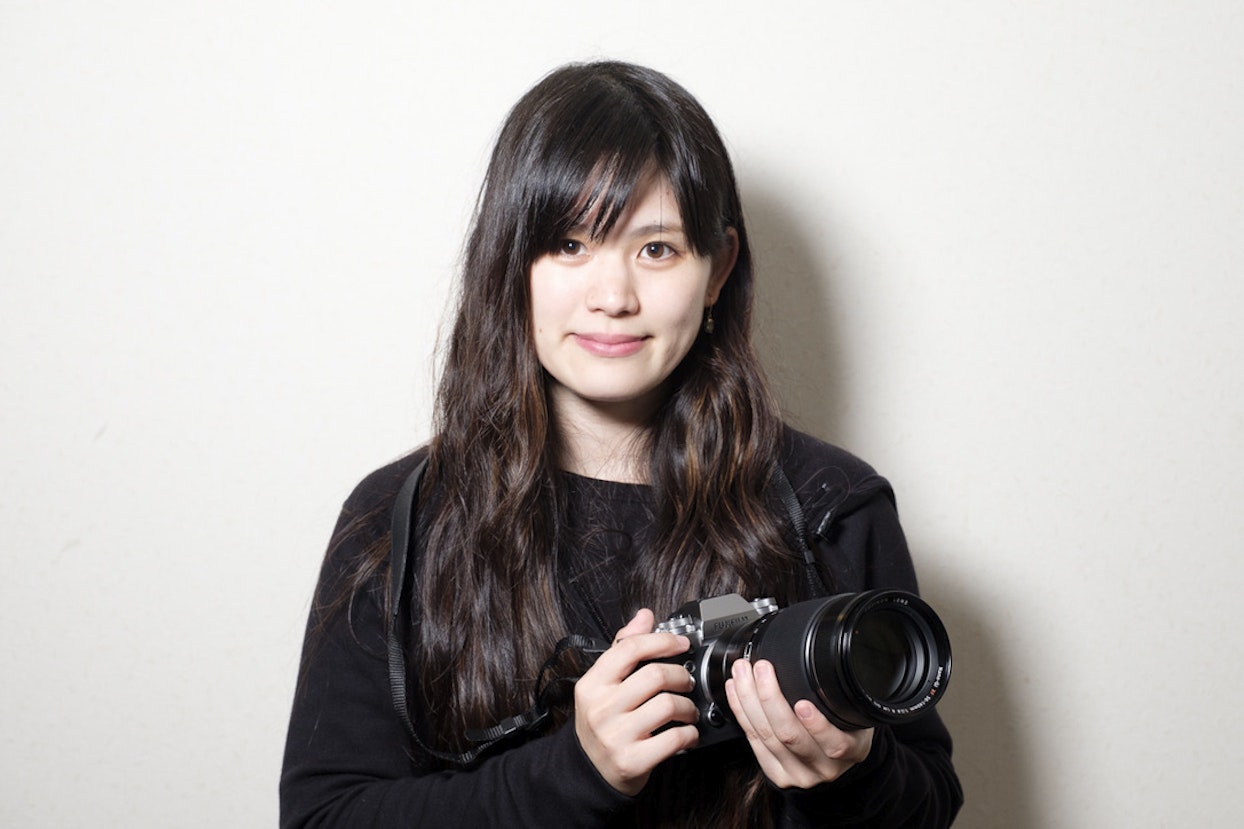 黒い服を着て、カメラを持っている女性の写真