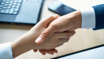 契約書のそばで握手が交わされている