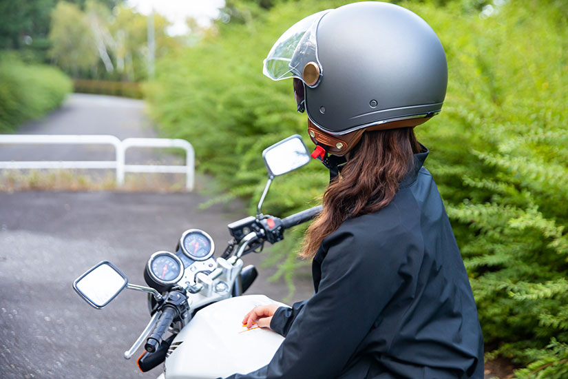 ヘルメットをかぶってバイクに乗っている女性