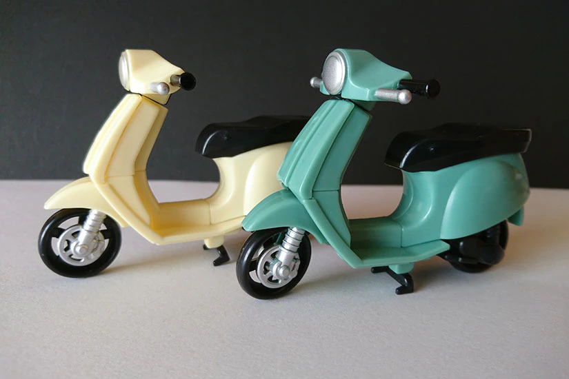 原付バイクの置物が2台並んでいる。それぞれ黄色と緑色。